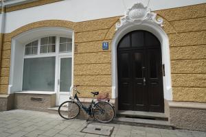 un vélo garé devant un immeuble avec une porte dans l'établissement HOMELY STAY Studio 1, à Munich