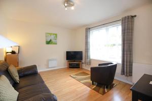 a living room with a couch and a television at Edinburgh Palace Apartment in Edinburgh