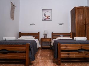 a room with two beds and two night stands at Kaloudis family in Agios Georgios