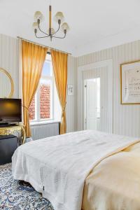 a bedroom with a large white bed and a window at Anno 1793 Sekelgården in Ystad