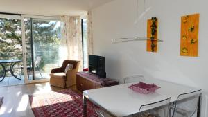 een woonkamer met een witte tafel en een televisie bij THE VIEW - Modern Panorama Residence in Bad Ischl