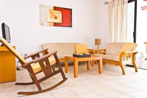 a living room with wooden furniture and a couch at Villas Mayaluum Cozumel in Cozumel