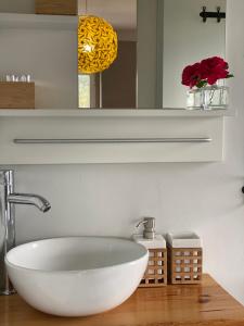 La salle de bains est pourvue d'un lavabo blanc et d'un miroir. dans l'établissement Quinta Janelas do Vale, à Abrantes