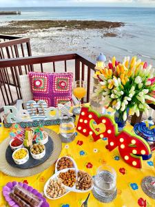アリナガにあるEmyCanarias Primera Línea De Playaのビーチでの食事と軽食を楽しめるテーブル