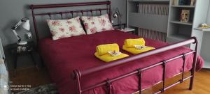 łóżko z dwoma żółtymi poduszkami na górze w obiekcie Areti' s Home w mieście Wolos
