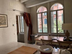 a dining room with a table and some windows at Cà del Console in Venice