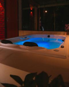 une baignoire jacuzzi avec des chaises dans la chambre dans l'établissement Chalé Canadense com Hidromassagem Pousada Índios Koroados, à Praia Grande