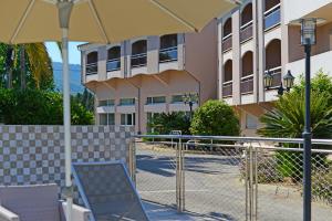 a chair and an umbrella in front of a building at Hotel Poretta in Lucciana