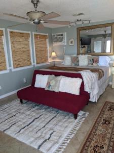 um quarto com uma cama grande e um sofá vermelho em Come Friday Cottages em Bacliff