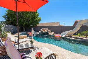 einen Pool mit Rutsche, Stühlen und Sonnenschirm in der Unterkunft 5 Bedroom 4 Bath Boutique Home PREMIUM LOCATION + heated pool option in Glendale