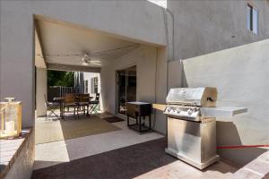 an outdoor kitchen with a stove and a table at 5 Bedroom 4 Bath Boutique Home PREMIUM LOCATION + heated pool option in Glendale