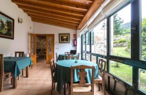 a dining room with a table and chairs and windows at Casa da Roncha in Noya