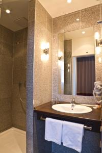 ein Bad mit einem Waschbecken und einem Spiegel in der Unterkunft Ivbergs Hotel Berlin Messe in Berlin
