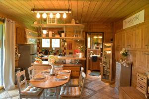 a kitchen with a wooden table and a dining room at Le Chalet d’Eliot in Chevigny