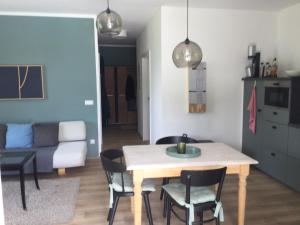 een eetkamer en een woonkamer met een tafel en stoelen bij STEINERGUT Gartenwohnung 1 in Vorderstoder