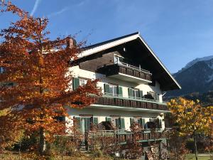 a large building with a balcony and a tree at STEINERGUT Gartenwohnung 1 in Vorderstoder
