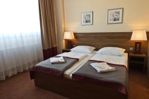 2 Betten in einem Hotelzimmer mit Handtüchern darauf in der Unterkunft Ivbergs Hotel Berlin Messe in Berlin