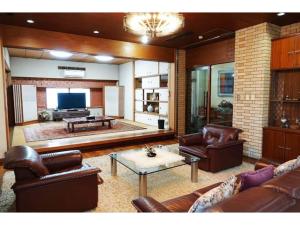 a living room with leather furniture and a flat screen tv at THE TORII - Vacation STAY 68438v in Kumamoto