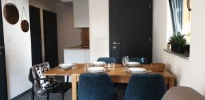 uma mesa de jantar com cadeiras azuis e uma mesa de madeira em Golte SkiCenter Apartment em Mozirje