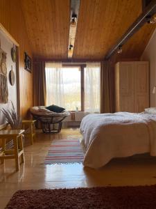 a bedroom with a bed and a large window at Cabana La Plai Vest - cozy private place in the mountain in Plaiu Şarului