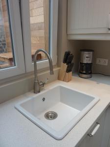 a white sink in a kitchen with a window at Aimée in Ypres