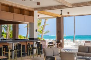 a bar with chairs and a view of the ocean at Caribe Deluxe Princess - All Inclusive in Punta Cana