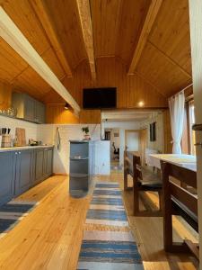 una cucina con soffitti in legno, tavolo e sedie di Cabana La Plai Vest - cozy private place in the mountain a Plaiu Şarului Altre 25 foto