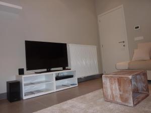a living room with a flat screen tv on a white entertainment center at Aimée in Ieper