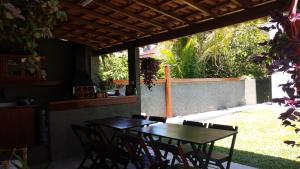 a table and chairs sitting under a pergola at Terral Casa de Praia in Guarujá