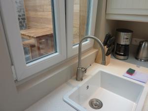 a kitchen counter with a sink and a window at Aimée in Ieper