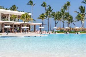 a beach with umbrellas and palm trees at Tropical Deluxe Princess - All Inclusive in Punta Cana
