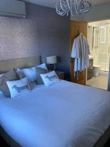 a bedroom with a large white bed with blue pillows at The Oaks, Luxury 2 bedroom cottage in a peaceful location in Haughley