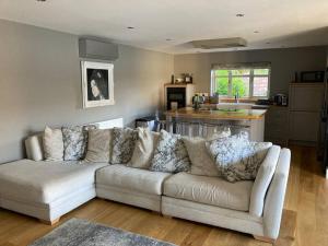 a living room with a white couch and a kitchen at The Oaks, Luxury 2 bedroom cottage in a peaceful location in Haughley +7 photos