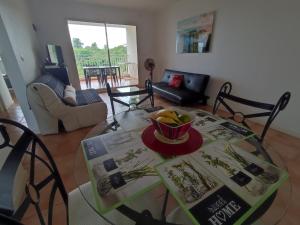 ein Wohnzimmer mit einem Glastisch und einer Obstschale in der Unterkunft KAZADIDOU - Résidence Grand Cap - Vue Mer et Montagne - Piscine in Le Gosier