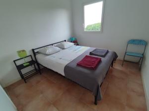 ein Schlafzimmer mit einem großen Bett und zwei Stühlen in der Unterkunft KAZADIDOU - Résidence Grand Cap - Vue Mer et Montagne - Piscine in Le Gosier + 37 Fotos