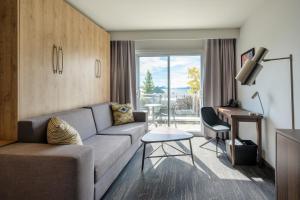 a living room with a couch and a table at Hôtel Versō in Magog-Orford