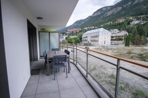 布里昂松SUPERB apt with BALCONY in BRIANÇON的带桌椅的阳台，可欣赏美景