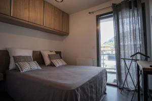 布里昂松SUPERB apt with BALCONY in BRIANÇON的一间带床和大窗户的卧室