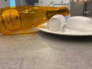 a bottle of wine sitting next to a plate with a cup at Bari Lory’s Home in Bari