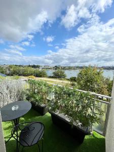 a balcony with three tables and a view of a river at LOVELY ! T2 de standing face à la rade in Larmor-Plage