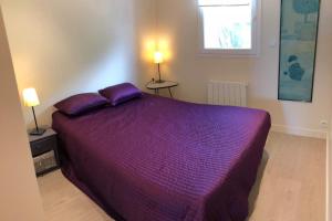 ラルモール・プラージュにあるAppartement Ultra cosy front de merのベッドルーム(紫色のベッド1台、ランプ2つ付)