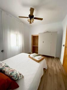 um quarto com uma cama e uma ventoinha de tecto em Casa Rural La abuela em El Campo