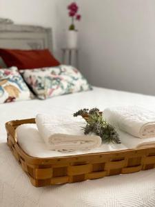 duas toalhas numa bandeja de madeira numa cama em Casa Rural La abuela em El Campo