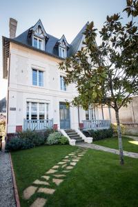 une maison blanche avec un arbre dans la cour dans l'établissement Villa Berry Centre Deauville - Chic & Stylée - Magnifique Jardin, à Deauville