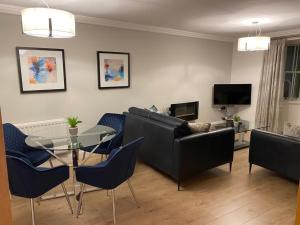 a living room with a couch and a table and chairs at GS - Luxury, modern town centre, 2 beds, free parking for one vehicle in Stratford-upon-Avon