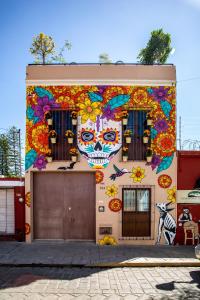 un edificio con cráneos pintados y flores en él en La Casa de Pino en Oaxaca de Juárez