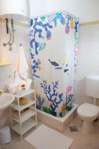 a bathroom with a shower curtain with a toilet at Apartments Bosiljka - by the sea in Sevid