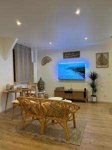 uma sala de estar com um sofá e uma televisão na parede em PARENTHESE LOVE - Bali Mon Amour Suite Balneo SPA Proche Orly-Paris em La Ville-du-Bois