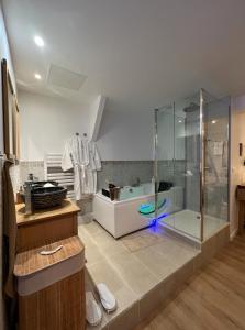 uma casa de banho com uma cabina de duche em vidro e uma banheira em PARENTHESE LOVE - Bali Mon Amour Suite Balneo SPA Proche Orly-Paris em La Ville-du-Bois