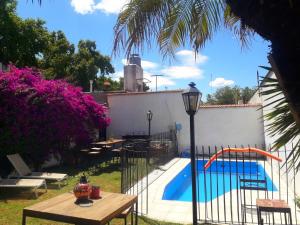a fence around a pool with a table and a lamp at Tanino Guest House in Mendoza